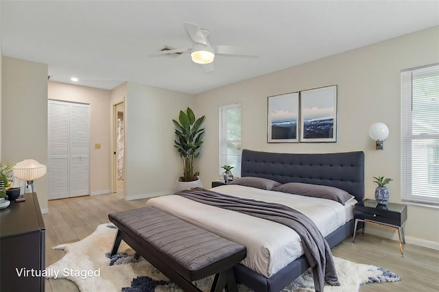 bedroom featuring light wood finished floors, baseboards, a closet, and ceiling fan