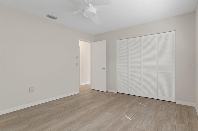 unfurnished bedroom featuring baseboards, ceiling fan, a closet, and light wood-type flooring