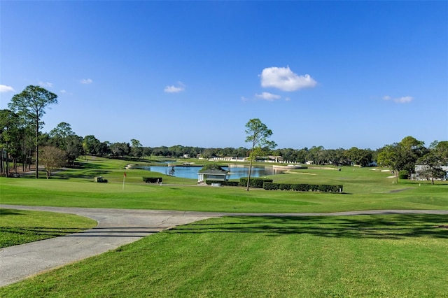 surrounding community featuring golf course view, a water view, and a lawn