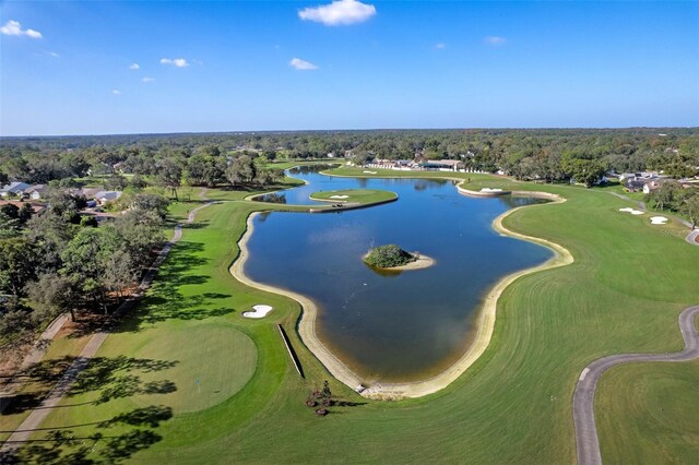 drone / aerial view with a water view, a view of trees, and view of golf course