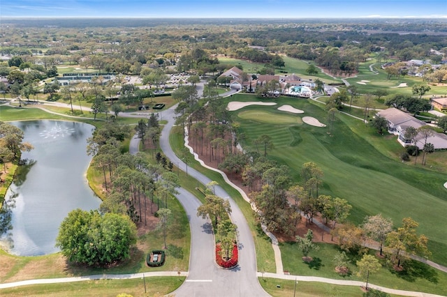 birds eye view of property with golf course view and a water view