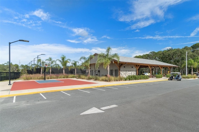 uncovered parking lot featuring community basketball court and fence