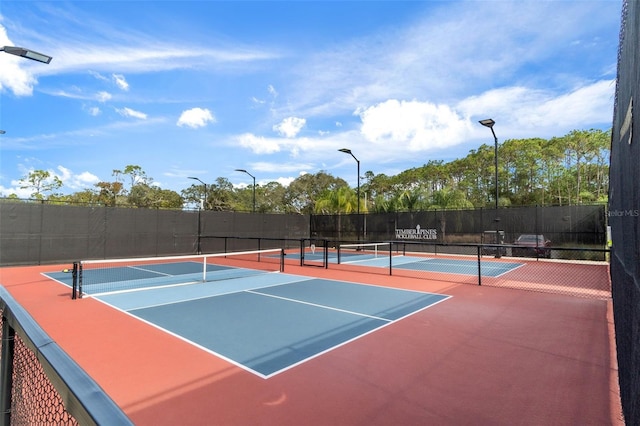 view of tennis court featuring community basketball court and fence