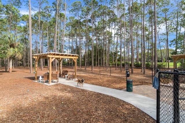 view of property's community featuring a fire pit, a pergola, fence, and a patio area