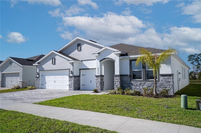 view of front of house with stone siding, a front yard, decorative driveway, and an attached garage
