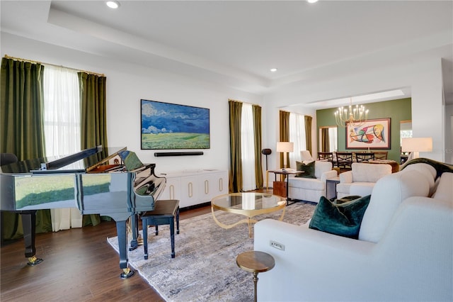 living room with dark wood-style flooring, a tray ceiling, a chandelier, and recessed lighting
