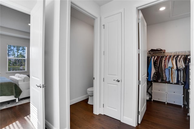 ensuite bathroom featuring toilet, ensuite bath, baseboards, and wood finished floors