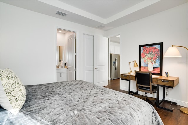 bedroom featuring stainless steel refrigerator with ice dispenser, baseboards, dark wood finished floors, ensuite bath, and visible vents