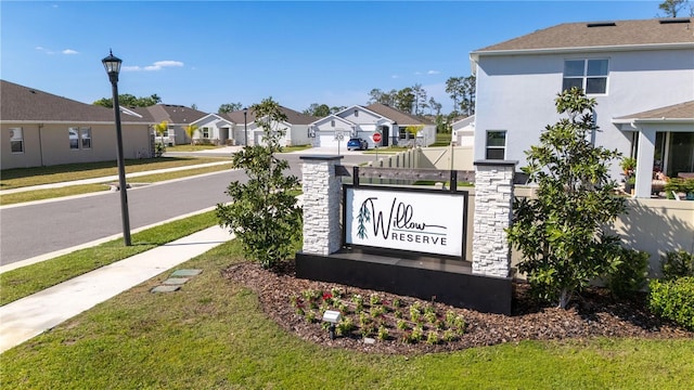 community / neighborhood sign featuring a residential view, fence, and a lawn