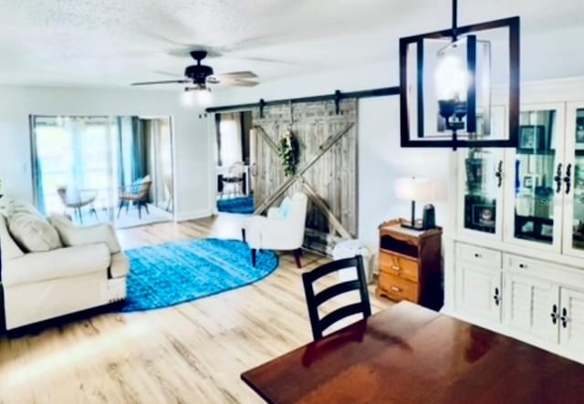717 Cordova Grn, Seminole, FL 33777 - living room featuring a barn door, a ceiling fan, and wood finished floors