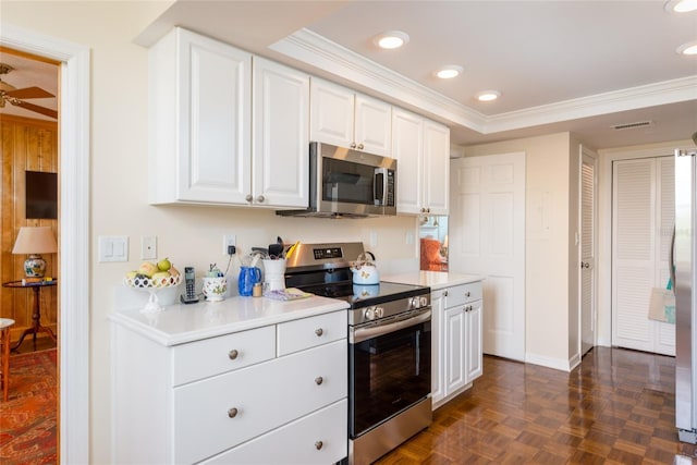 kitchen with white cabinets, crown molding, stainless steel appliances, baseboards, and visible vents