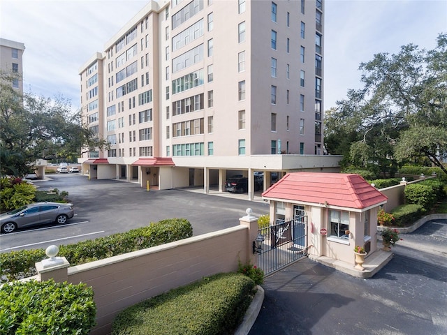 view of property featuring covered and uncovered parking