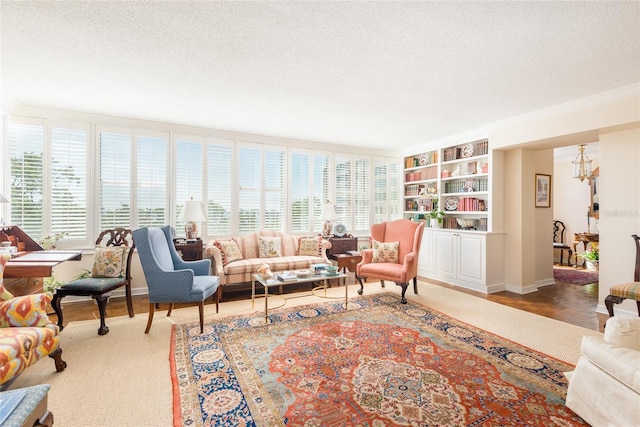 living area with an inviting chandelier, a textured ceiling, and a wealth of natural light