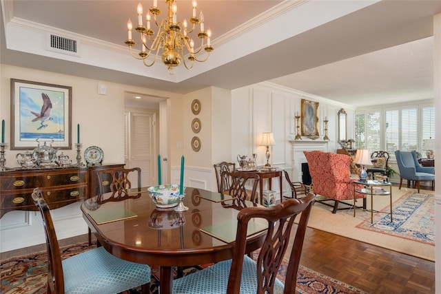 dining area featuring visible vents, ornamental molding, a decorative wall, and a notable chandelier