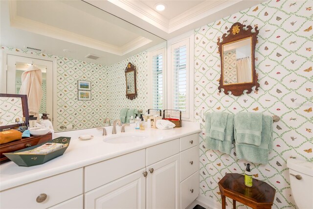 full bathroom featuring visible vents, crown molding, vanity, a raised ceiling, and toilet