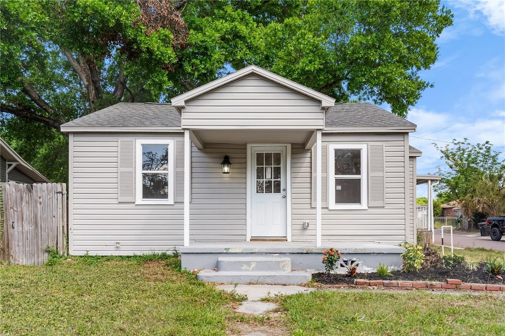 3413 N 12th St, Tampa, FL 33605 - bungalow-style house featuring a shingled roof, a front yard, and fence