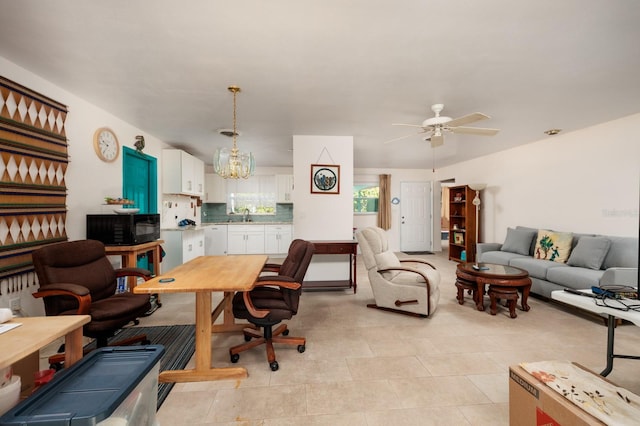 office space with light tile patterned floors, a sink, and ceiling fan with notable chandelier