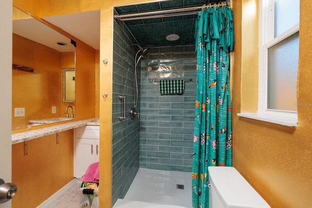 full bathroom featuring tiled shower and vanity