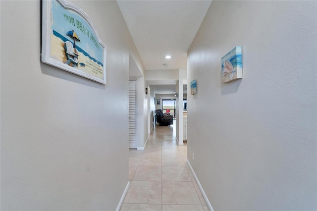 hallway featuring light tile patterned floors and baseboards