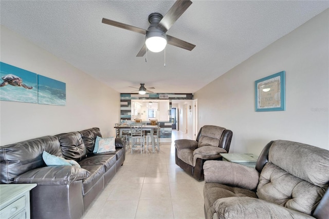 living area with light tile patterned flooring, a textured ceiling, and a ceiling fan