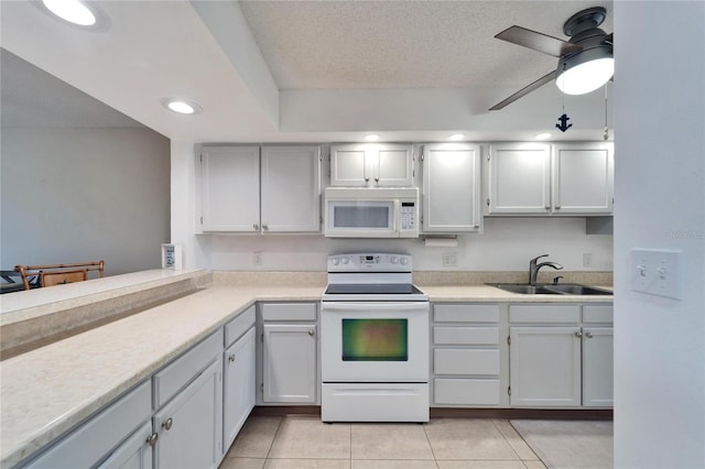 kitchen featuring white appliances, light countertops, a sink, and light tile patterned floors