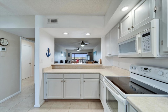 kitchen with light countertops, light tile patterned floors, and white appliances