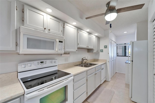 kitchen with light countertops, a sink, a textured ceiling, and white appliances