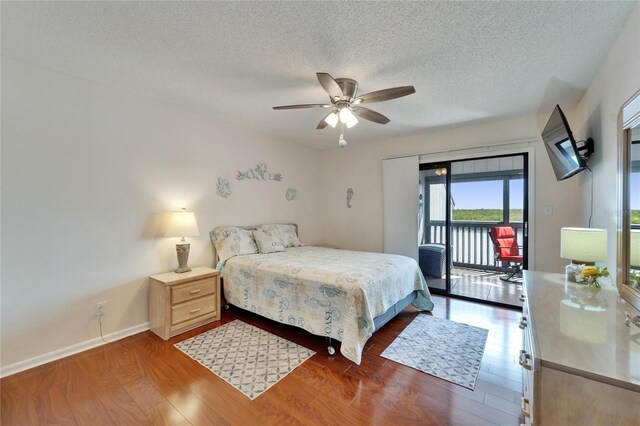 bedroom featuring access to exterior, a ceiling fan, wood finished floors, a textured ceiling, and baseboards