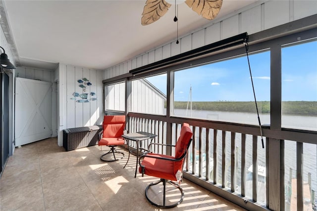 sunroom / solarium with a water view and ceiling fan