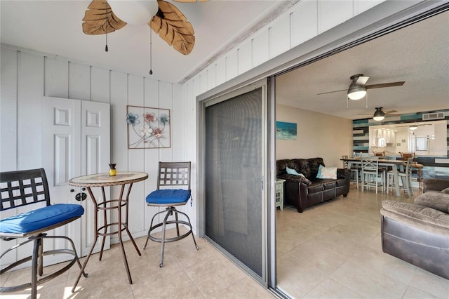 interior space with light tile patterned flooring and ceiling fan