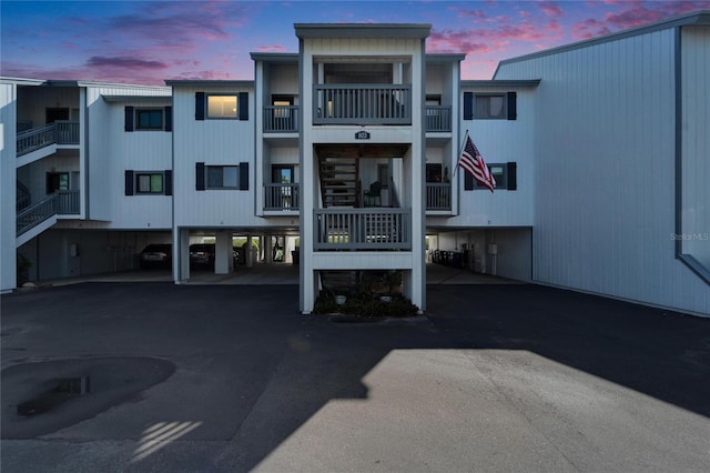 view of property featuring covered parking and stairway