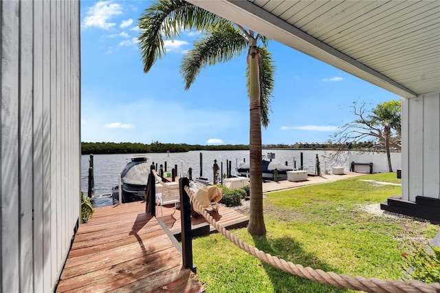 dock area with a water view and a yard