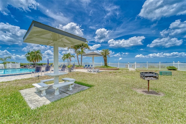 view of yard featuring a community pool, fence, and a patio area