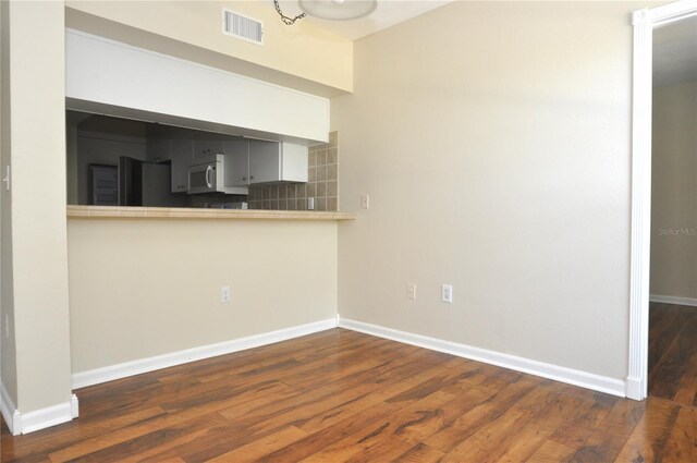 3358 Mermoor Dr Unit 2106, Palm Harbor, FL 34685 - kitchen featuring baseboards, white microwave, visible vents, and wood finished floors