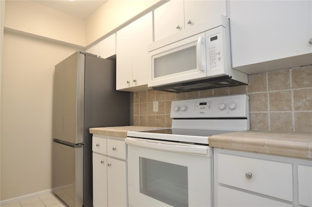 3358 Mermoor Dr Unit 2106, Palm Harbor, FL 34685 - kitchen with white cabinetry, tile countertops, tasteful backsplash, and white appliances