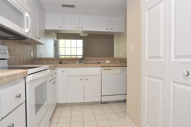3358 Mermoor Dr Unit 2106, Palm Harbor, FL 34685 - kitchen with backsplash, white cabinetry, light tile patterned floors, white appliances, and visible vents