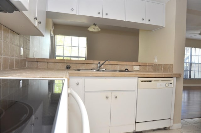 3358 Mermoor Dr Unit 2106, Palm Harbor, FL 34685 - kitchen with white cabinetry, a sink, white dishwasher, and decorative backsplash