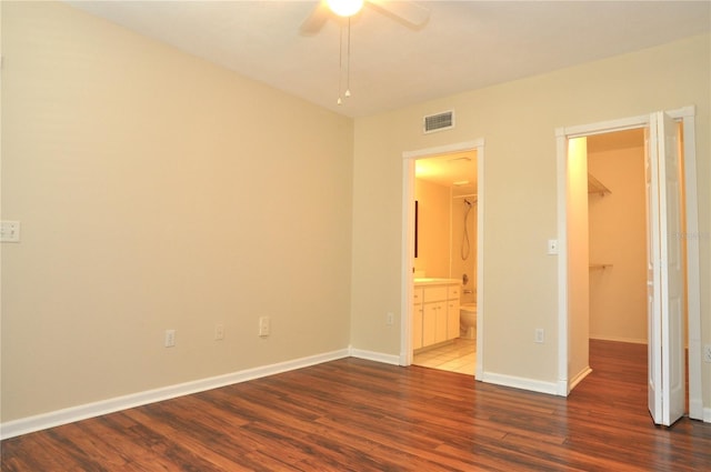 3358 Mermoor Dr Unit 2106, Palm Harbor, FL 34685 - unfurnished bedroom featuring a spacious closet, baseboards, connected bathroom, visible vents, and wood finished floors