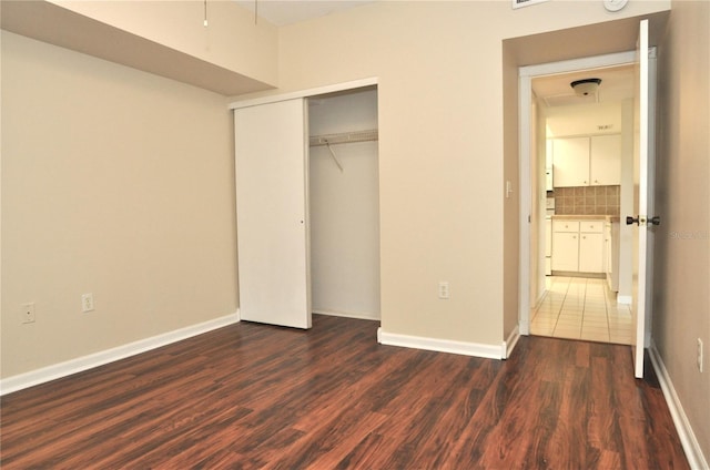 3358 Mermoor Dr Unit 2106, Palm Harbor, FL 34685 - unfurnished bedroom with dark wood-style floors, a closet, and baseboards