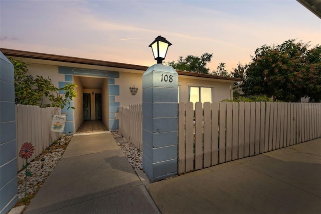 view of front of home with stucco siding and fence
