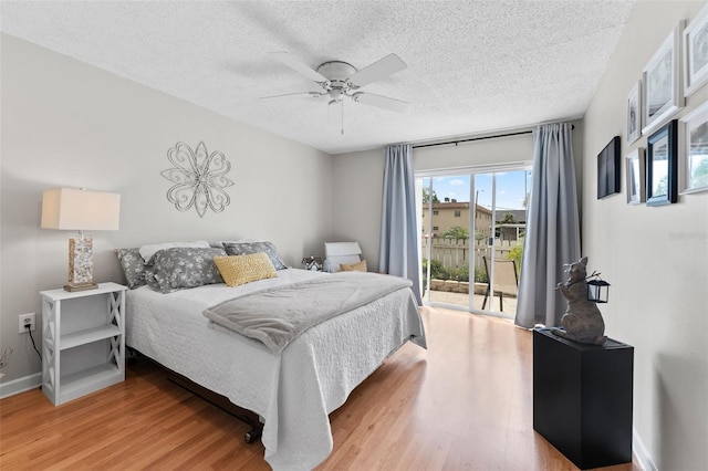 bedroom with baseboards, access to exterior, light wood finished floors, and a textured ceiling