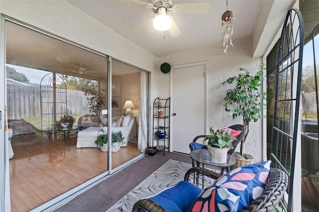 sunroom / solarium featuring a ceiling fan