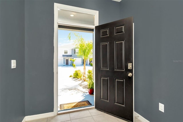 foyer with light tile patterned floors and baseboards