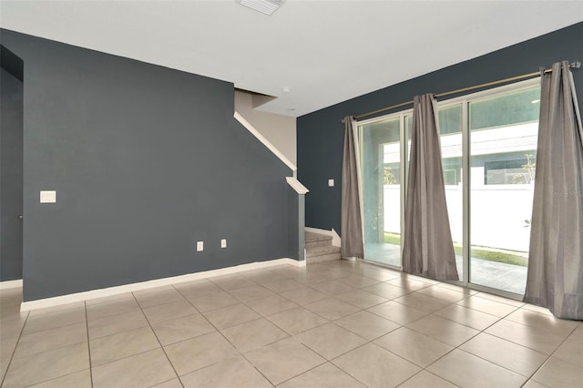 empty room with plenty of natural light, stairs, and baseboards