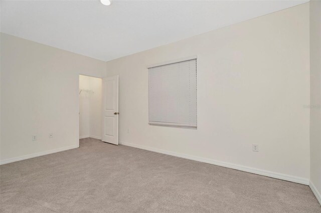 carpeted empty room featuring baseboards