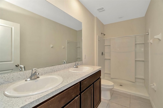 full bath with toilet, a sink, tile patterned floors, and a stall shower