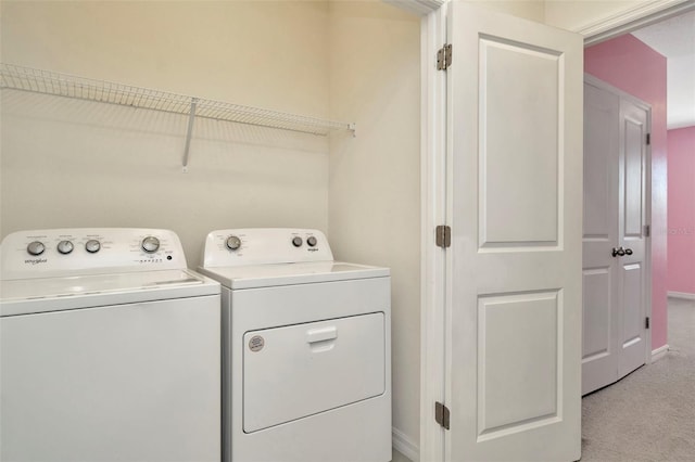 laundry room with baseboards, washing machine and dryer, laundry area, and light carpet