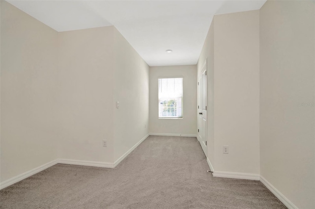 empty room with light carpet and baseboards