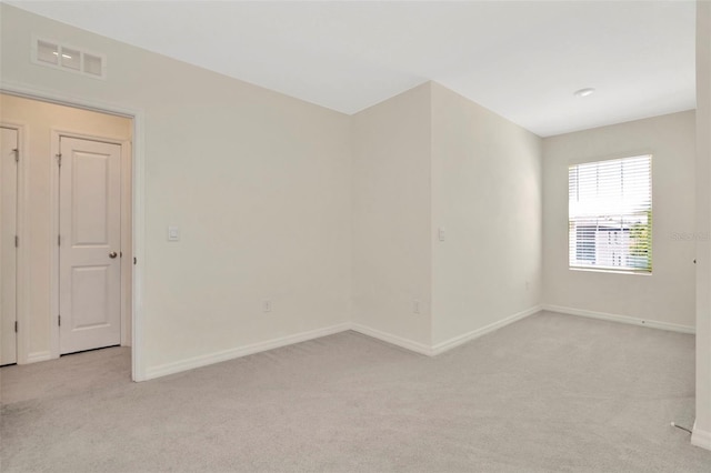 unfurnished room with light carpet, baseboards, and visible vents
