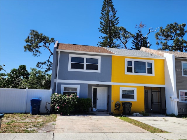 townhome / multi-family property featuring stucco siding, fence, and a shingled roof
